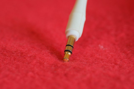 White jack plug on red background