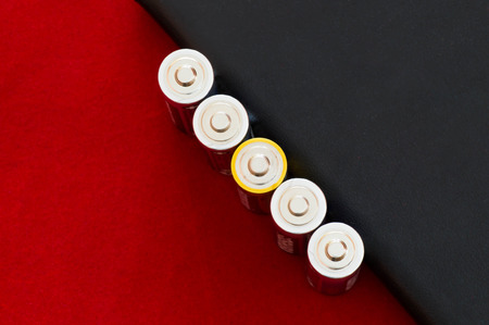 Be different concept with AA batteries in a row where one battery has a different top colorの写真素材