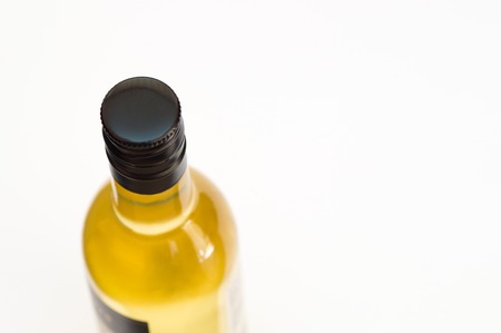 Bottle of liquid in upper view with black metal cup on itの写真素材