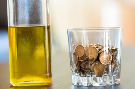 Drinking concept with a glass of coins
