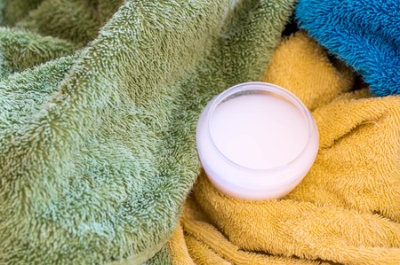 Filled measuring cup with liquid detergents on towels