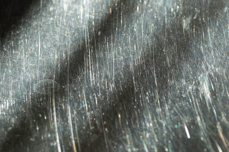 Scratched metal surface with a white dot on itの写真素材