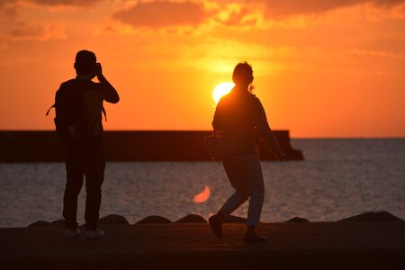 people visiting the shore at duskの写真素材