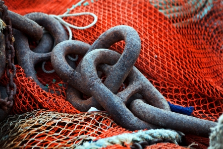 Heavy iron fishing chain with an orange colored nilon fishing networksの写真素材
