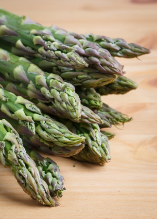 Bunch of fresh green asparagus spears on a rustic wooden tableの写真素材