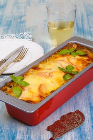 Meat casserole with mozzarella and tomatoes on the tableの写真素材