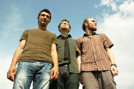 three young men standing outdoorの写真素材