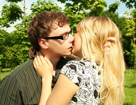 young man and girl kissing outdoorの写真素材