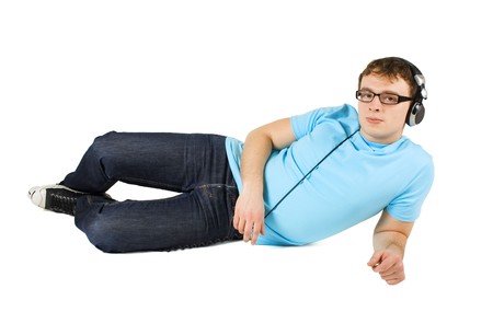 man in blue shirt with midi keyboard and headphones lies isolated on whiteの写真素材