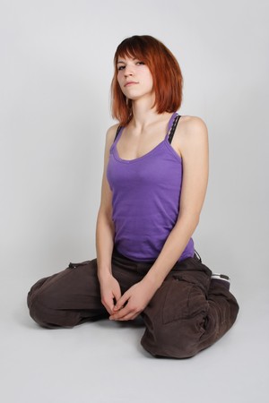 young redhead girl in hip-hop clothes sitting and looking at camera, full bodyの写真素材