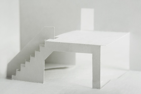 paper cutout composition with white elements of building, terrace with stairs and doorの写真素材