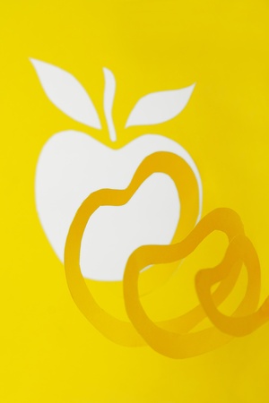 abstract cutout yellow paper composition, apple and rind in spiral shapeの写真素材