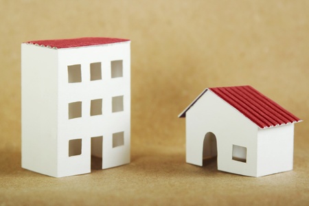 paper models of village and city dwelling houses with red roofs, brown backgroundの写真素材