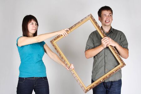 woman wresting gold decorative frame from man, angry faces