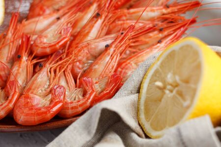 Healthy grilled prawns served with a halved lemon and napkin to clean ones fingers during eatingの写真素材