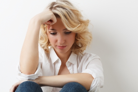 Sadness blonde young girl on white backgroundの写真素材