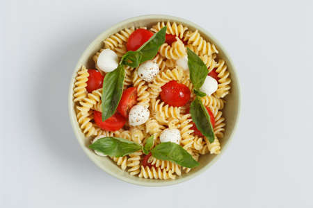 Pasta salad with cherry tomatoes and basil leaves の写真素材