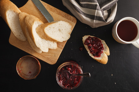bread and raspberries jam on black background. Overhead viewの写真素材