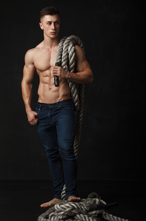 Portrait of a handsome young man with great physique over black backgroundの写真素材