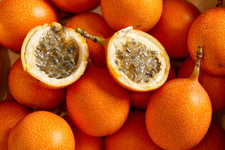 Top view of bunch of fresh passion fruit in the organic food market. One fruit cutted