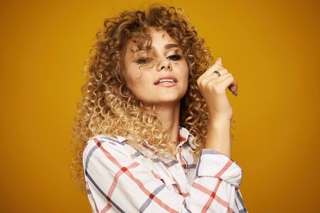Beauty portrait of young girl with afro hairstyle. Girl posing on yellow background. Studio shotの写真素材