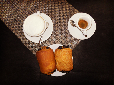 Italian breakfast with coffee, cappuccino and two chocolate briocheesの写真素材