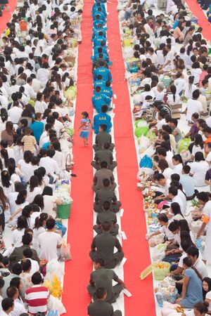 people in rows are waiting for giving alms のeditorial素材