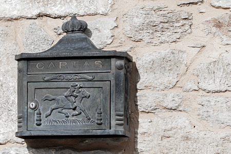 Rustic iron mailbox on a stone wallの写真素材