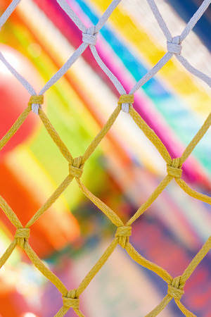 Yellow and white net and very colorful background in children playgroundの写真素材