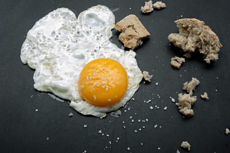 Fried egg and bread on a cast iron griddleの写真素材