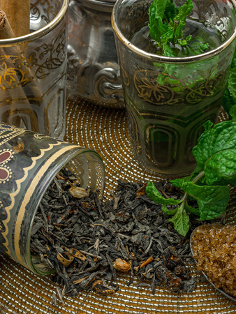 Black tea in a crystal glass mint leaves dried tea brown sugar and cinnamon .の写真素材