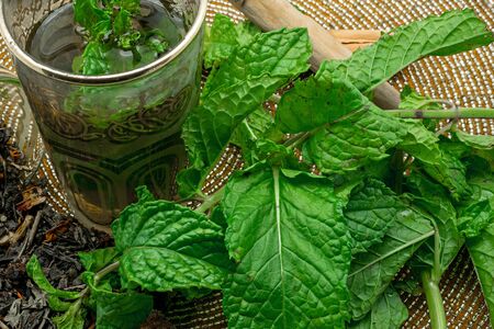 Black tea in a crystal glass mint leaves dried tea brown sugar and cinnamon .の写真素材