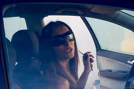 Pretty young woman in car. View through the car windowの写真素材