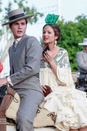 Seville, Spain - April 28, 2015: Couple in traditional dress riding at the April Fair Seville. The Seville Fair "Feria de abril de Sevilla" is one of most important celebration of the city, it begins one or two week after easter Holy Weekのeditorial素材