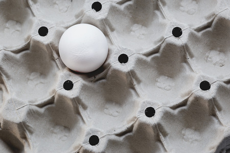One white egg in a carton box. Top viewの写真素材