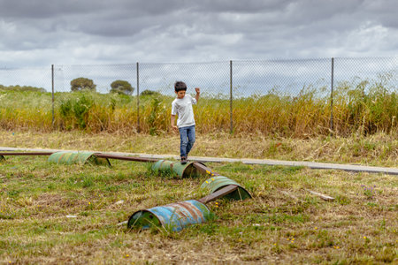 Seville, Spain - May 7, 2016: Boy walking over barrels in playground area at Spanish Aerodrome. Skydive Spain is the skydiving center located at La Juliana Aerodrome, about 20 km southwest of Seville, Spain. At Skydive Spain they fly up to 15,000ft, the hのeditorial素材