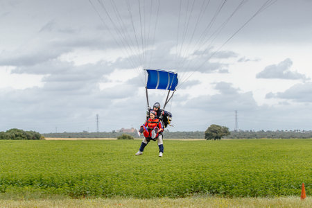 Seville, Spain - May 7, 2016: Tandem skydive landing in Seville. Skydive Spain is the skydiving center located at La Juliana Aerodrome, about 20 km southwest of Seville, Spain. At Skydive Spain they fly up to 15,000ft, the highest altitude in Europe and oのeditorial素材