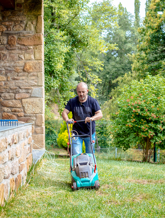 Man cutting grass in his gardenの写真素材