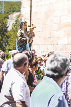 Lubian, Spain - August 05, 2016: People in Procession, pilgrimage in honor of the Virgen of the Tuiza. Sanctuary of La Virgen de la Tuiza which keeps Las Nieves Virgin (Patron Saint of the High Sanabria). Built in granite ashlar masonry, this Sanctuary shのeditorial素材