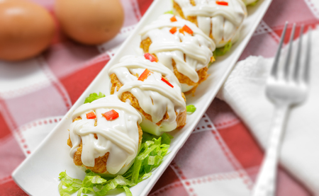 Stuffed eggs with tuna, tomato, mayonnaise and red pepper on white backgroundの写真素材