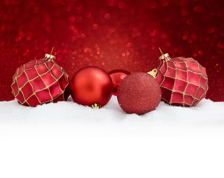 Red christmas balls on snow with glitter background. Merry christmas cardの写真素材