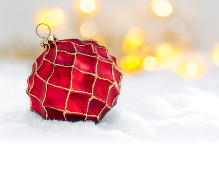 Red Christmas ball in the snow and defocused lightsの写真素材