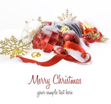 Christmas ornaments  in the snow with red ribbonの写真素材