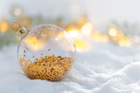 Christmas decoration glass ball at snowy sunriseの写真素材
