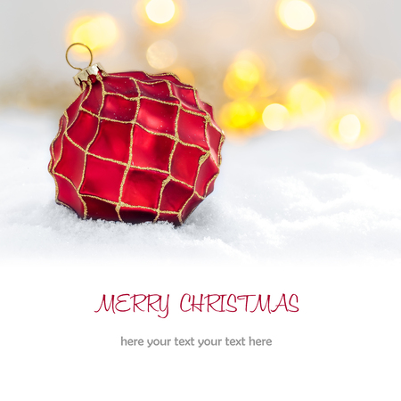 Red Christmas ball in the snow and defocused lightsの写真素材