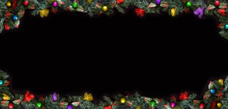 Christmas framework, black background decorated with balls and tree branches and space for a greeting text.の写真素材