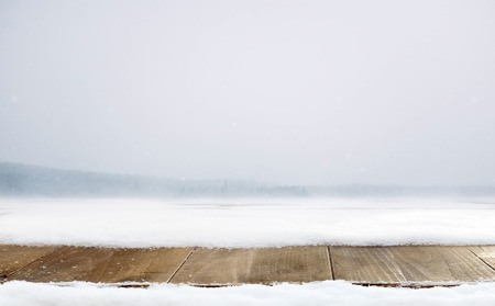 Wooden desk and winter decoration of snow with mountains landscapeの写真素材