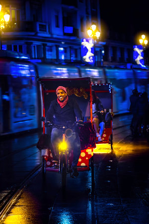 Seville, Spain - December 16, 2016: Tourists enjoying a Tricycle ride at christmas night in Historical center of Seville, Spain.のeditorial素材