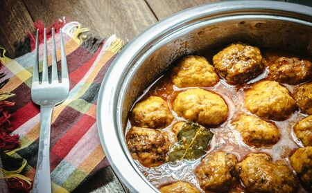 Homemade Meat balls in tomato and curry sauce on wooden backgroundの写真素材