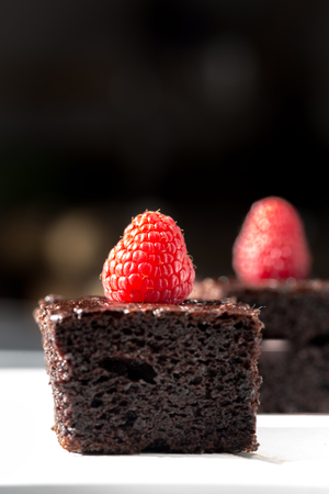 Pieces of Dark chocolate cake decorated with raspberriesの写真素材